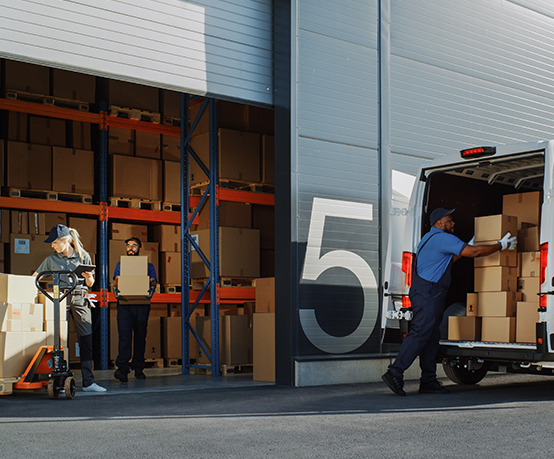 Outside of Logistics Retailer Warehouse With Manager Using Tablet Computer